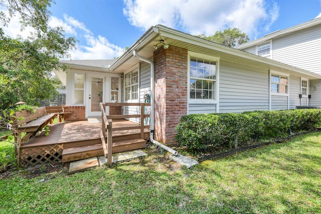 1536 San Rafael Way, Saint Augustine, FL 32080 - view of exterior entry with brick siding, a deck, and a lawn
