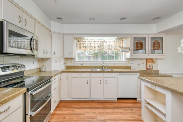 1536 San Rafael Way, Saint Augustine, FL 32080 - kitchen with stainless steel appliances, a sink, tasteful backsplash, light countertops, and light wood finished floors