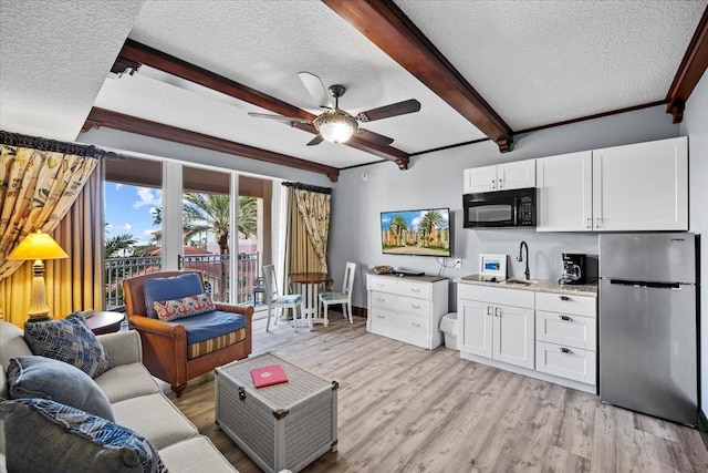 living room with light wood-type flooring, beam ceiling, ceiling fan, a textured ceiling, and crown molding