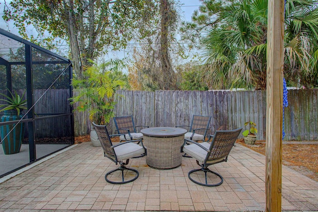 view of patio featuring a lanai