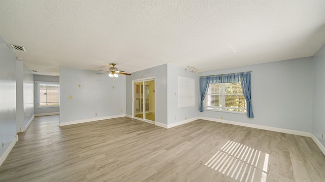 empty room with light hardwood / wood-style flooring and a wealth of natural light