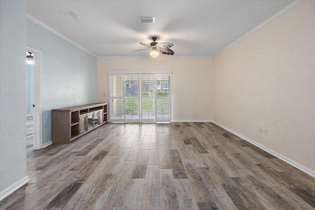 unfurnished living room with baseboards, crown molding, visible vents, and wood finished floors