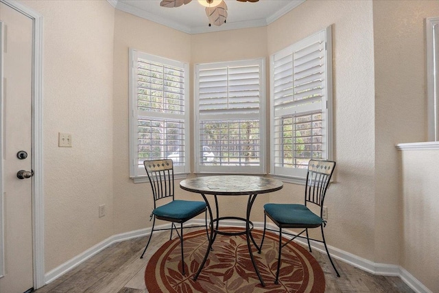 dining area with a wealth of natural light, baseboards, crown molding, and wood finished floors