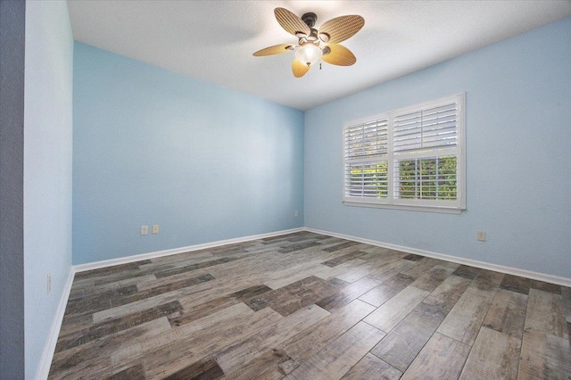 spare room with ceiling fan, baseboards, and wood finished floors