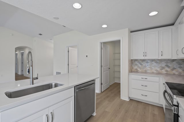 30 Palm Ln, Palm Coast, FL 32164 - kitchen featuring appliances with stainless steel finishes, a sink, light wood finished floors, arched walkways, and white cabinets