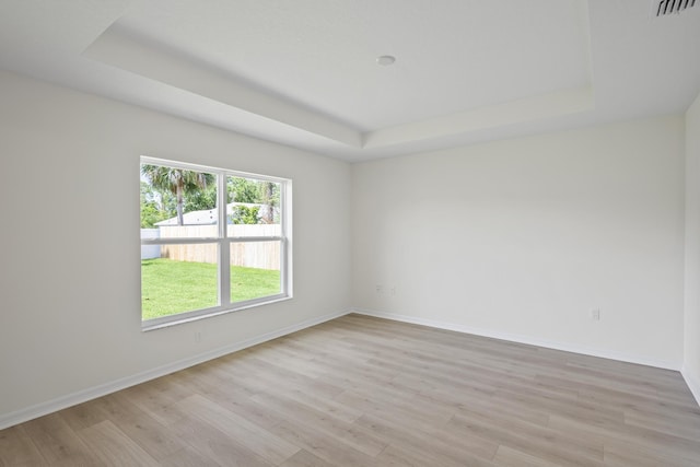30 Palm Ln, Palm Coast, FL 32164 - unfurnished room with a tray ceiling, light wood finished floors, and baseboards