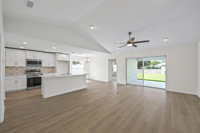 30 Palm Ln, Palm Coast, FL 32164 - unfurnished living room featuring vaulted ceiling, ceiling fan, healthy amount of natural light, light wood-type flooring, and recessed lighting