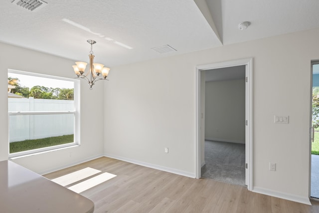 30 Palm Ln, Palm Coast, FL 32164 - spare room featuring light wood finished floors, a chandelier, and baseboards