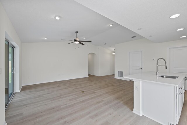 30 Palm Ln, Palm Coast, FL 32164 - kitchen with a sink, light countertops, light wood-type flooring, open floor plan, and white cabinetry