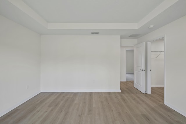 30 Palm Ln, Palm Coast, FL 32164 - unfurnished bedroom featuring a tray ceiling, light wood finished floors, and baseboards