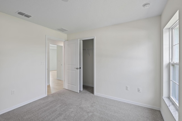 30 Palm Ln, Palm Coast, FL 32164 - unfurnished bedroom with light carpet, multiple windows, baseboards, and a closet