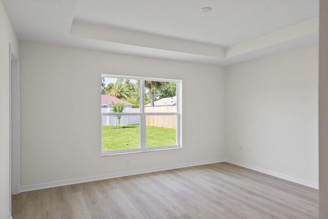 30 Palm Ln, Palm Coast, FL 32164 - unfurnished room featuring healthy amount of natural light, wood finished floors, a raised ceiling, and baseboards