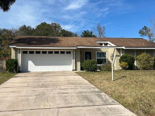 single story home with a garage and a front yard