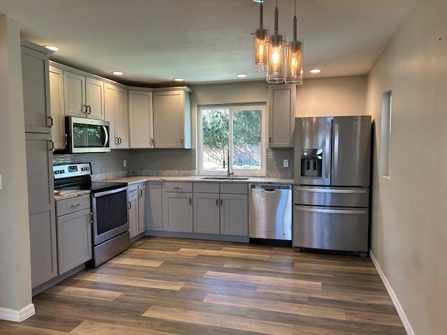 kitchen featuring stainless steel appliances, sink, and gray cabinetry