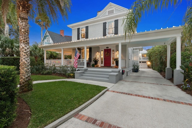 farmhouse inspired home featuring a porch and a front lawn