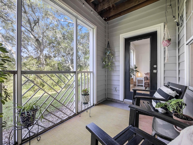 sunroom featuring beam ceiling