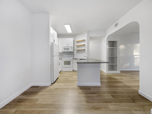kitchen featuring open shelves, dark countertops, white appliances, a peninsula, and white cabinetry
