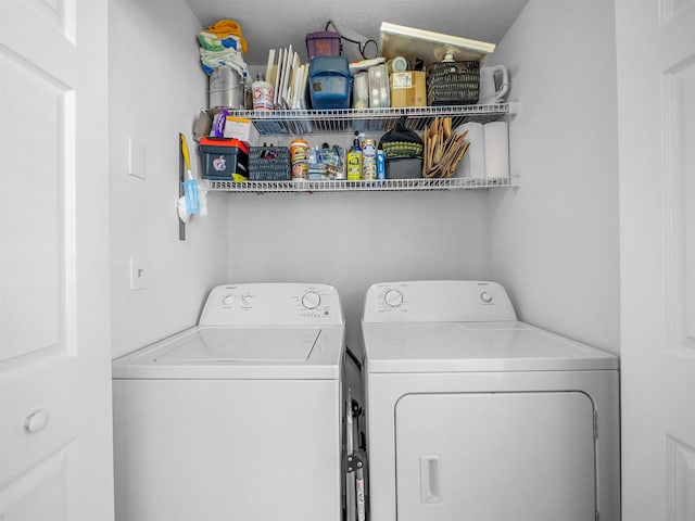 clothes washing area with a textured ceiling and washer and clothes dryer