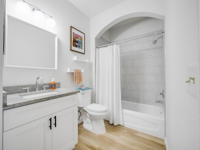 full bathroom featuring vanity, wood-type flooring, shower / tub combo, and toilet