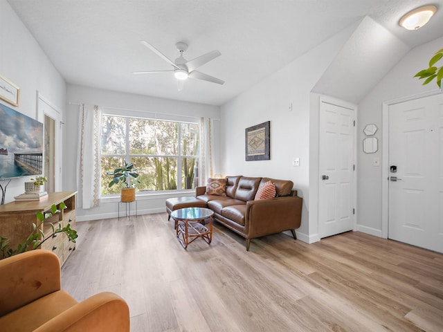 living room with light wood-type flooring, vaulted ceiling, and ceiling fan