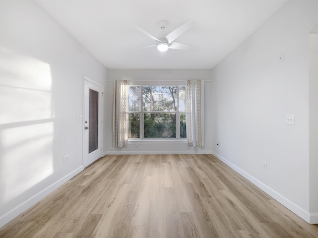 spare room featuring light wood-style floors, baseboards, and a ceiling fan
