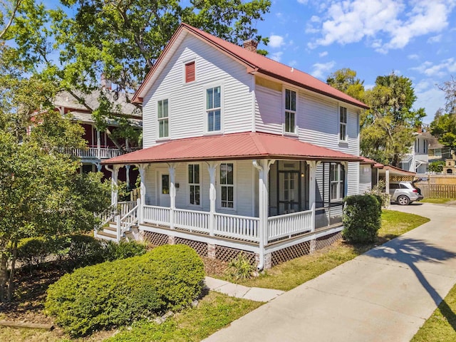 44 Carrera St, Saint Augustine, FL 32084 - view of front facade with covered porch, a chimney, and metal roof