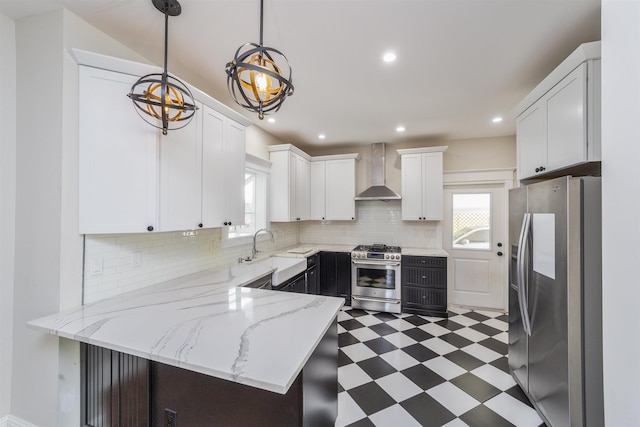 44 Carrera St, Saint Augustine, FL 32084 - kitchen featuring appliances with stainless steel finishes, wall chimney range hood, tile patterned floors, a sink, and a peninsula