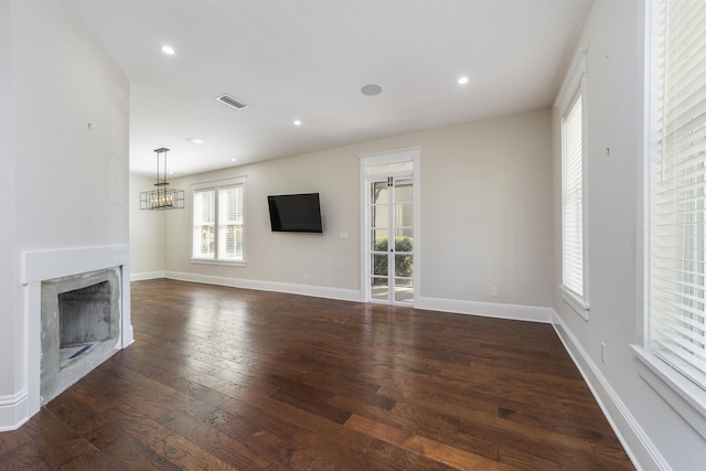 44 Carrera St, Saint Augustine, FL 32084 - unfurnished living room with hardwood / wood-style flooring, a premium fireplace, a chandelier, baseboards, and recessed lighting