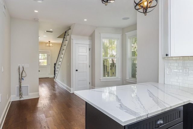 44 Carrera St, Saint Augustine, FL 32084 - kitchen with dark wood-type flooring, light stone counters, white cabinets, recessed lighting, and baseboards