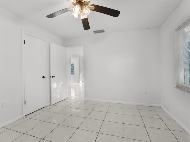 spare room with ceiling fan and light tile patterned flooring