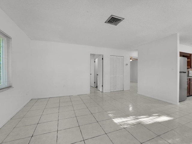 tiled spare room with ceiling fan