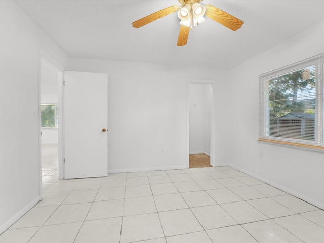 tiled empty room with ceiling fan