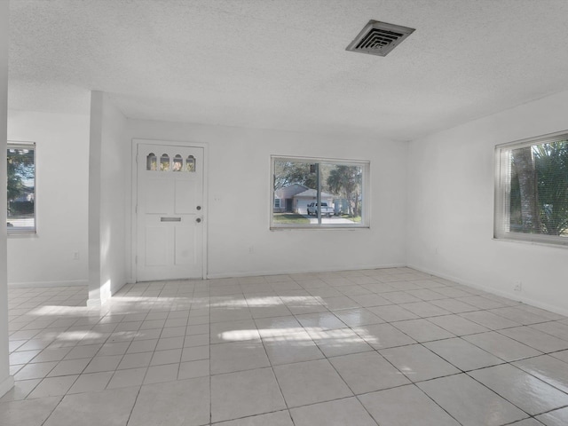 tiled foyer entrance featuring a textured ceiling