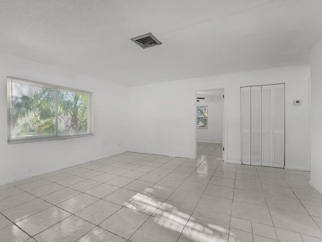 tiled empty room featuring ceiling fan