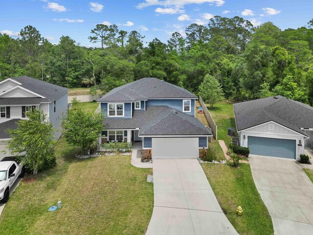121 Sawmill Forest Ct, Saint Augustine, FL 32086 - traditional home with a garage, a shingled roof, concrete driveway, and a front yard