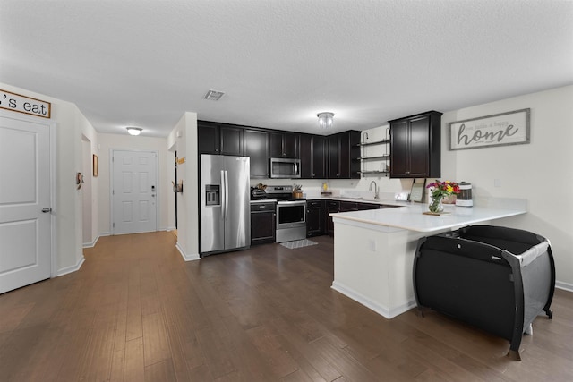 121 Sawmill Forest Ct, Saint Augustine, FL 32086 - kitchen featuring visible vents, light countertops, a peninsula, stainless steel appliances, and dark wood-type flooring