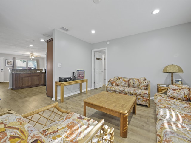 living room with ceiling fan and light hardwood / wood-style flooring