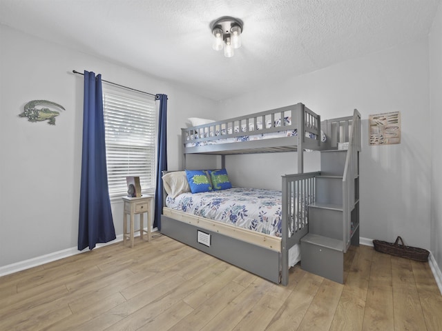 bedroom with wood-type flooring and a textured ceiling