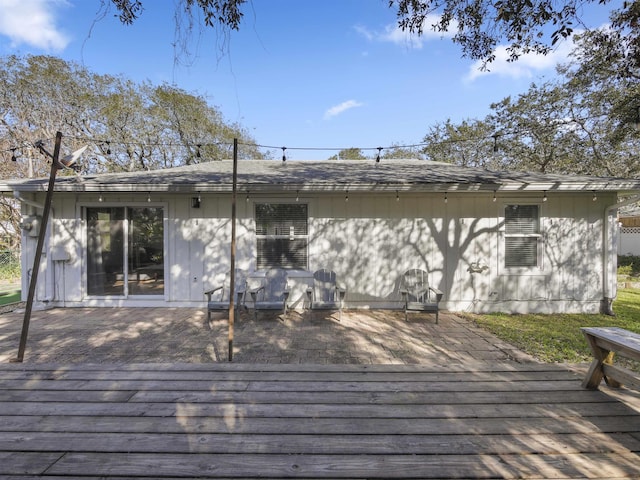 rear view of house featuring a wooden deck