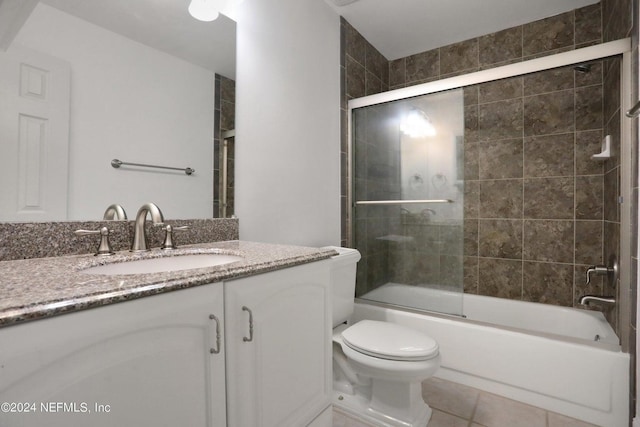 full bathroom with vanity, bath / shower combo with glass door, tile patterned floors, and toilet