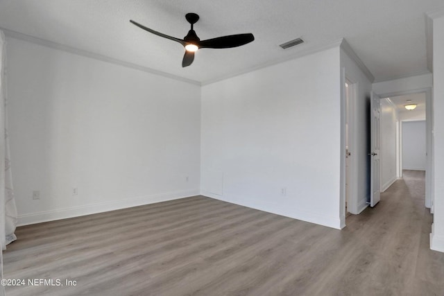 empty room with crown molding, a textured ceiling, ceiling fan, and light hardwood / wood-style floors