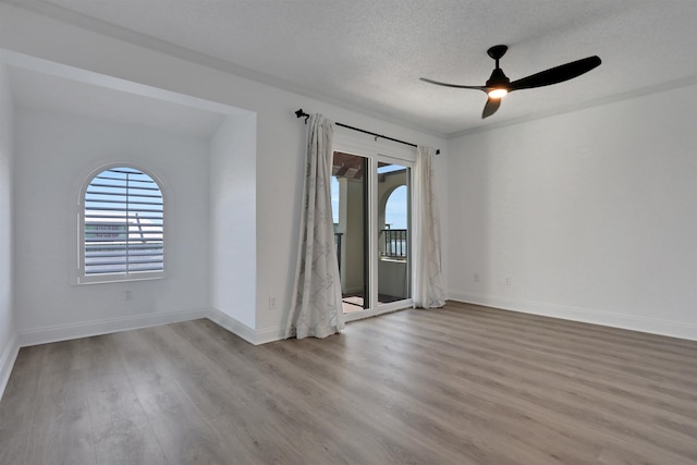 empty room featuring ceiling fan, a textured ceiling, and light wood-type flooring