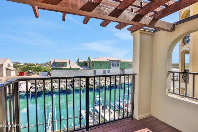 balcony with a water view and a pergola