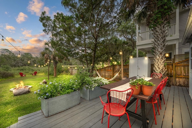 29 Oak St, Saint Augustine, FL 32084 - wooden terrace with an outdoor fire pit, outdoor dining area, a fenced backyard, and a storage unit