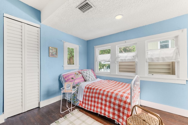29 Oak St, Saint Augustine, FL 32084 - bedroom with multiple windows, baseboards, wood finished floors, and a textured ceiling