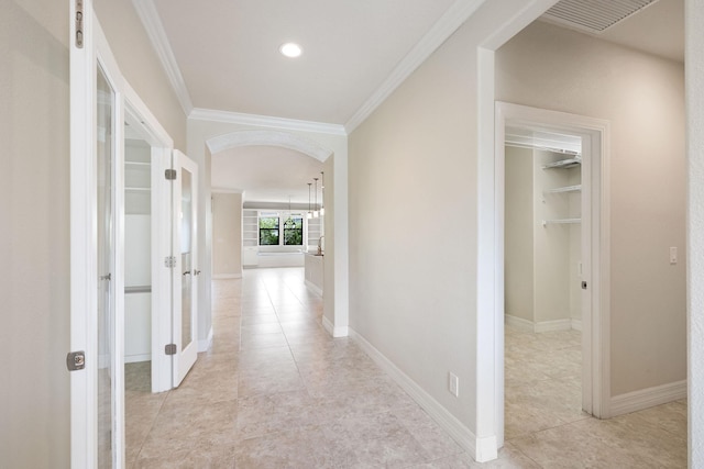 hall with light tile patterned flooring and ornamental molding