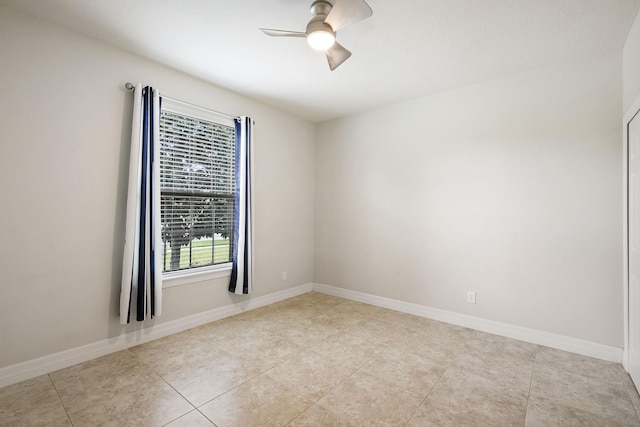 empty room featuring light tile patterned floors, baseboards, and a ceiling fan