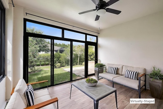 living room with a wealth of natural light, a ceiling fan, and wood finished floors