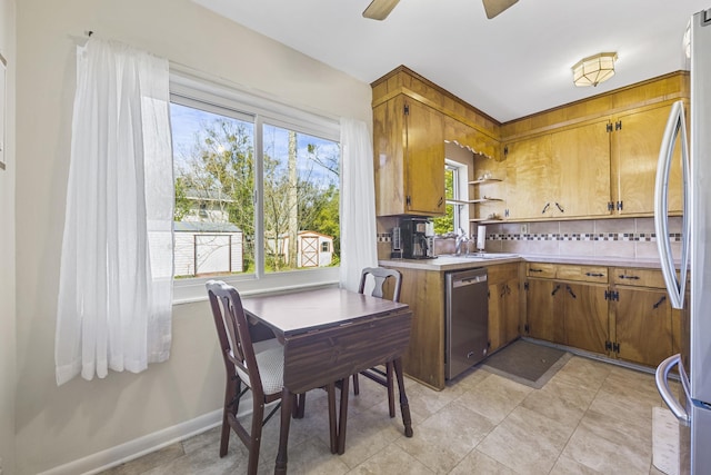 kitchen featuring light countertops, brown cabinets, backsplash, and stainless steel appliances