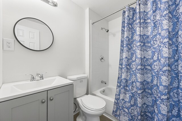 bathroom featuring toilet, shower / tub combo with curtain, and vanity